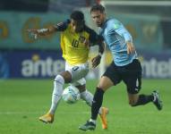 Gonzalo Plata disputa el balón con un jugador uruguayo.