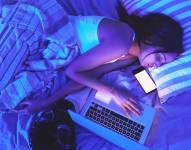 Mujer se queda dormida con el celular y la computadora.