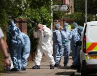 Oficiales forenses trabajan en la escena de un incidente que involucró a un hombre con una espada.