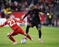 Nilson Angulo, extremo de la selección de Ecuador, disputa el balón contra Niko Sigur, defensa de Canadá