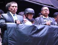 El candidato Christian Zurita (centro) con agentes de seguridad y con una cobija antibalas durante un mitin que se realizó el 17 de agosto.
