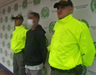 Policia de Colombia junto a un detenido