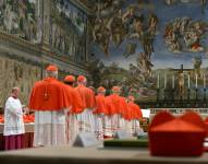 Cardenales haciendo fila en la Capilla Sixtina para jurar sobre la Biblia no revelar jamás los secretos de sus deliberaciones antes del inicio del cónclave en el Vaticano, el 12 de marzo de 2013.