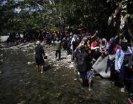 Migrantes esperan para ser trasladados en canoa desde la Quebrada León hasta la comunidad de Bajo Chiquito, en Darién (Panamá), en una fotografía de archivo