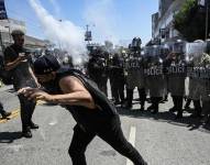 Agentes del orden, incluyendo miembros del Equipo de Respuesta Especial del Servicio de Inmigración y Control de Aduanas (ICE) y agentes de Seguridad Nacional, confrontan a manifestantes.