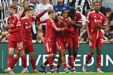 El delantero inglés del Liverpool, #73 Rio Ngumoha (C), celebra con sus compañeros después de anotar el tercer gol durante el partido de la Premier League inglesa entre Newcastle United y Liverpool en St James' Park