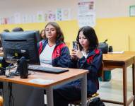 Imagen de una estudiante de un colegio ecuatoriano usando su celular en una clase de computación.