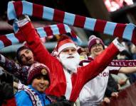 Aficionados de clubes ingleses asisten disfrazados de Papá Noel sabiendo que se celebran fechas navideñas.