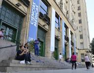 Personas descansan frente a la Facultad de Medicina de la Universidad de Buenos Aires (UBA) este lunes, en Buenos Aires (Argentina). EFE/ Matías Martin Campaya