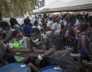 Varios migrantes haitianos se reúnen antes de abordar un bote hacia Capurganá, cerca de la frontera con Panamá, el miércoles 28 de julio de 2021, en Necoclí, Colombia.