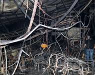 Unos hombres iraníes inspeccionan la escena del incendio que se ha provocado en un salón de bodas este miércoles en Hamndaniya, Irak, en el que han muerto más de 100 personas y, al menos, 150 han resultado heridas, durante la celebración de una boda cristiana.