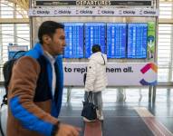 Una pasajera mira el estado de los vuelos en un monitor en el Aeropuerto Ronald Reagan de Arlington, Virginia, el 11 de enero de 2023. EFE/Shawn Thew