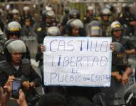 Miembros de la policía vigilan a cientos de manifestantes a favor de Pedro Castillo y en contra del Congreso que se manifiestan en las calles del centro, hoy en Lima (Perú).