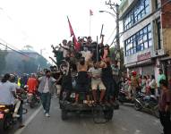 Los manifestantes llevan la bandera nacional de Nepal mientras viajan en un camión policial afuera de la Casa Presidencial en Katmandú el 9 de septiembre de 2025, un día después de una represión policial a las manifestaciones por las prohibiciones de las redes sociales y la corrupción del gobierno.