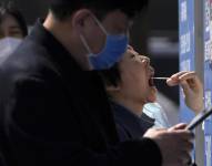 Gente haciendo fila para hacerse pruebas diagnósticas de COVID-19 el martes 5 de abril, en Beijing.