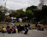 Manifestantes se cubren durante un enfrentamiento con la policía, en una jornada de protestas el 28 de mayo de 2021 en Cali (Colombia).