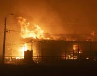 Fotografía de una casa en llamas por un incendio que comenzó en la reserva natural del lago Peñuelas y ha llegado hasta las zonas urbanas hoy, en Viña del Mar.