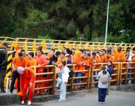 Fotografía cedida por la Cancillería de Colombia que muestra un grupo de colombianos deportados desde Ecuador este sábado, sobre el puente internacional de Rumichaca en Ipiales (Colombia).