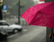 Imagen de una persona sosteniendo un paraguas mientras llueve.