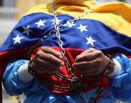 Un hombre encadenado se manifiesta afuera de la embajada de Venezuela este viernes, en Lima.