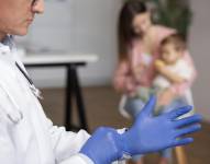 Madre joven con su niño pequeño en el pediatra para un examen físico.