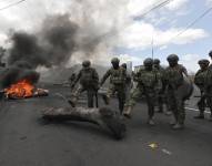 Soldados de las Fuerzas Armadas remueven escombros después de una protesta en la Panamericana Norte este martes, en Tabacundo.