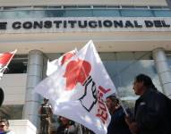 Personas con banderas de la CEOLS en los exteriores de la Corte Constitucional.