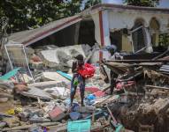 Unas mujeres recuperan sus pertenencias de sus casas destrozadas en Les Cayes, Haití, luego del terremoto.
