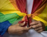Repreetación de un mimebro de la comunidad LGBTQI+ portadno la bandera de arcoíris.