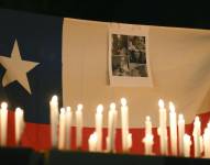 Fotografía de una bandera de Chile con retratos de los mineros atrapados en El Teniente, durante una vigilia en el control de acceso Los Maitenes, en Rancagua (Chile) .