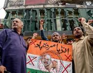 Personas con carteles gritan consignas antiindias frente a los cristales rotos de un restaurante cerca del estadio de críquet de Rawalpindi tras el presunto ataque con un dron, ocurrido en Rawalpindi el 8 de mayo de 2025.