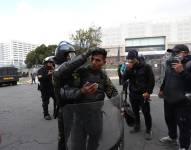 Policías dispersan a manifestantes que tratan de llegar a la sede de la Asamblea Nacional hoy, en Quito.