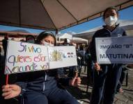 QUITO (ECUADOR), 18/10/2021.- Dos niñas muestran carteles antes de recibir una dosis de la vacuna contra la covid-19 durante una jornada de vacunación a niños de 6 a 11 años.