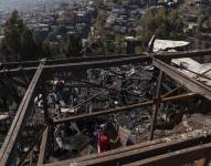 Personas retiran escombros de las viviendas destruidas por un incendio en Valparaíso, en Chile.