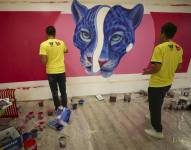 Artistas dibujan un jaguar en un centro comercial de Quito.
