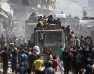 Palestinos alrededor de camiones con ayuda humanitaria.