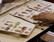 Fotografía de archivo del 13 de marzo de 2022 que muestra a un jurado de votación que organiza los tarjetones de votación, en Bogotá (Colombia).