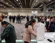 Votantes ecuatorianos preparan sus papeletas en el centro de votación instalado en el centro de convenciones IFEMA de Madrid.