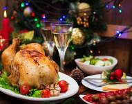 Baked turkey or chicken. The Christmas table is served with a turkey, decorated with bright tinsel and candles. Fried chicken, table. Christmas dinner.