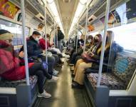 Personas con cubrebocas debido al coronavirus viajan en el metro de Londres el 28 de noviembre de 2021.