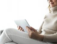 Imagen referencial: Mujer leyendo libros electrónicos en tableta.