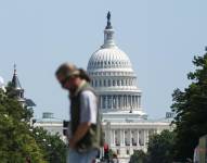 Foto de archivo que muestra a un transeúnte cruzando la avenida Pensilvania frente al Capitolio de los Estados Unidos, en Washington D. C.