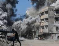 Un hombre palestino se pone a cubierto tras un ataque aéreo israelí durante una operación militar en Gaza.