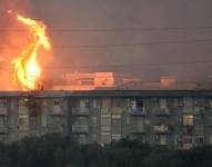 Una columna de fuego se eleva tras un bloque de viviendas en el área de Monte Grifone en la ciudad de Ciaculli, cerca de Palermo, en Italia.
