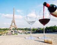 Una persona sirve una copa de vino con vista a la torre Eiffel en París, Francia