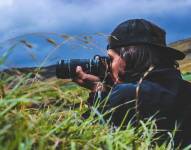 Imagen referencial para graficar cómo un fotógrafo captura un paisaje con su cámara.