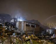 Un bombero camina entre los escombros de una casa dañada en el barrio de San Juan de Miraflores, tras un incendio que dañó al menos 100 viviendas en Lima el 11 de octubre de 2025.