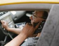 Imagen de una persona recibiendo una llamada dentro de un vehículo.