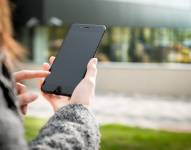 Una mujer revisando su teléfono celular.