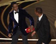 El presentador Chris Rock, a la izquierda, reacciona tras ser confrontado por Will Smith mientras presentaba el premio al mejor documental en la ceremonia de los Oscar.